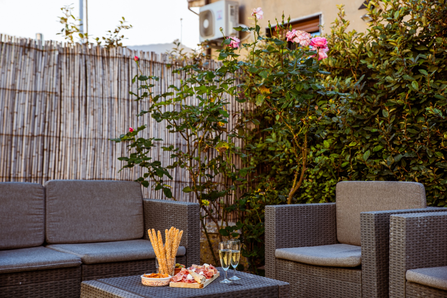 Apéritif dressé sur la table basse du salon de jardin en fin de journée
