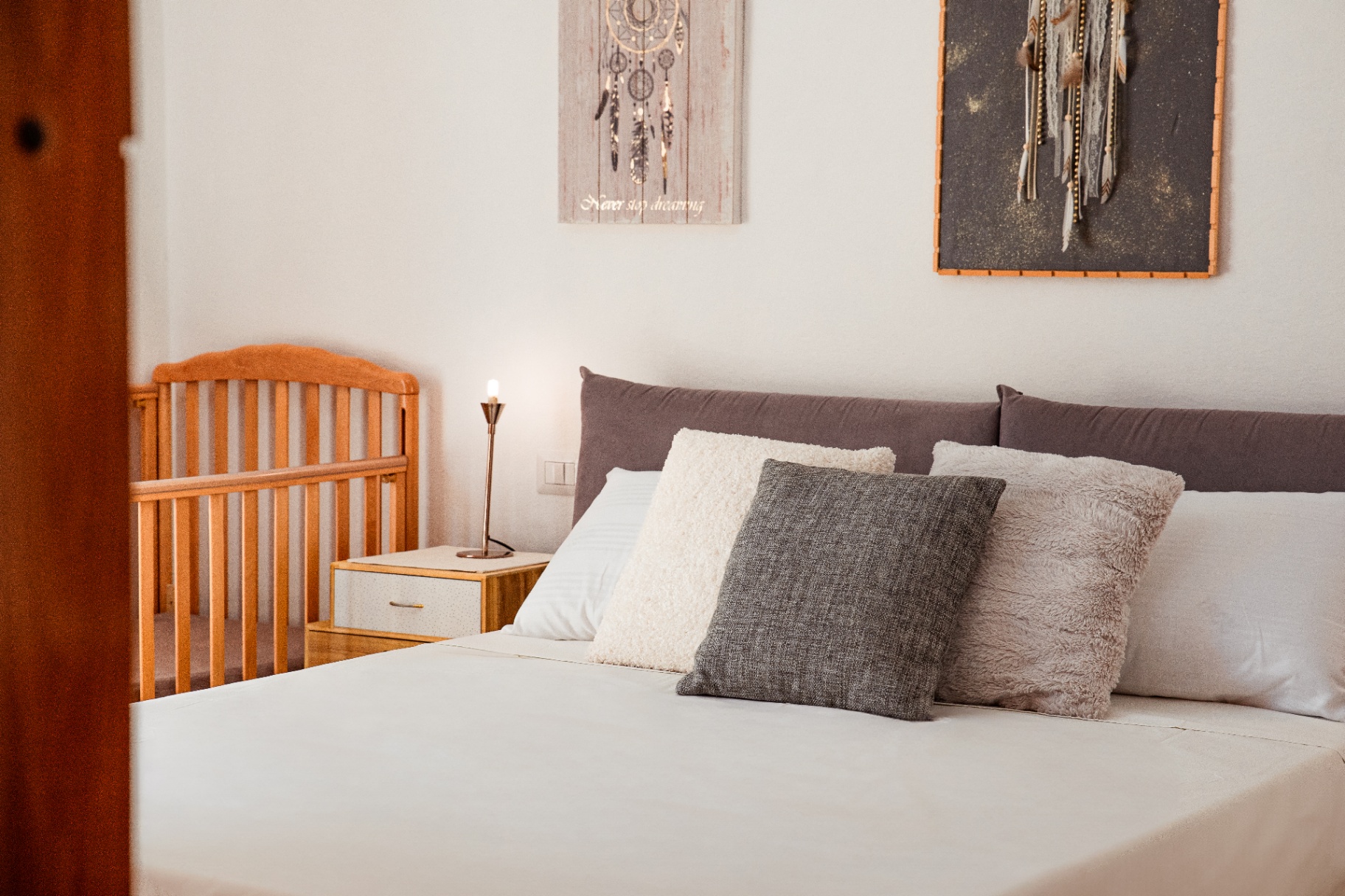Lit bébé en hêtre installé près du lit king size