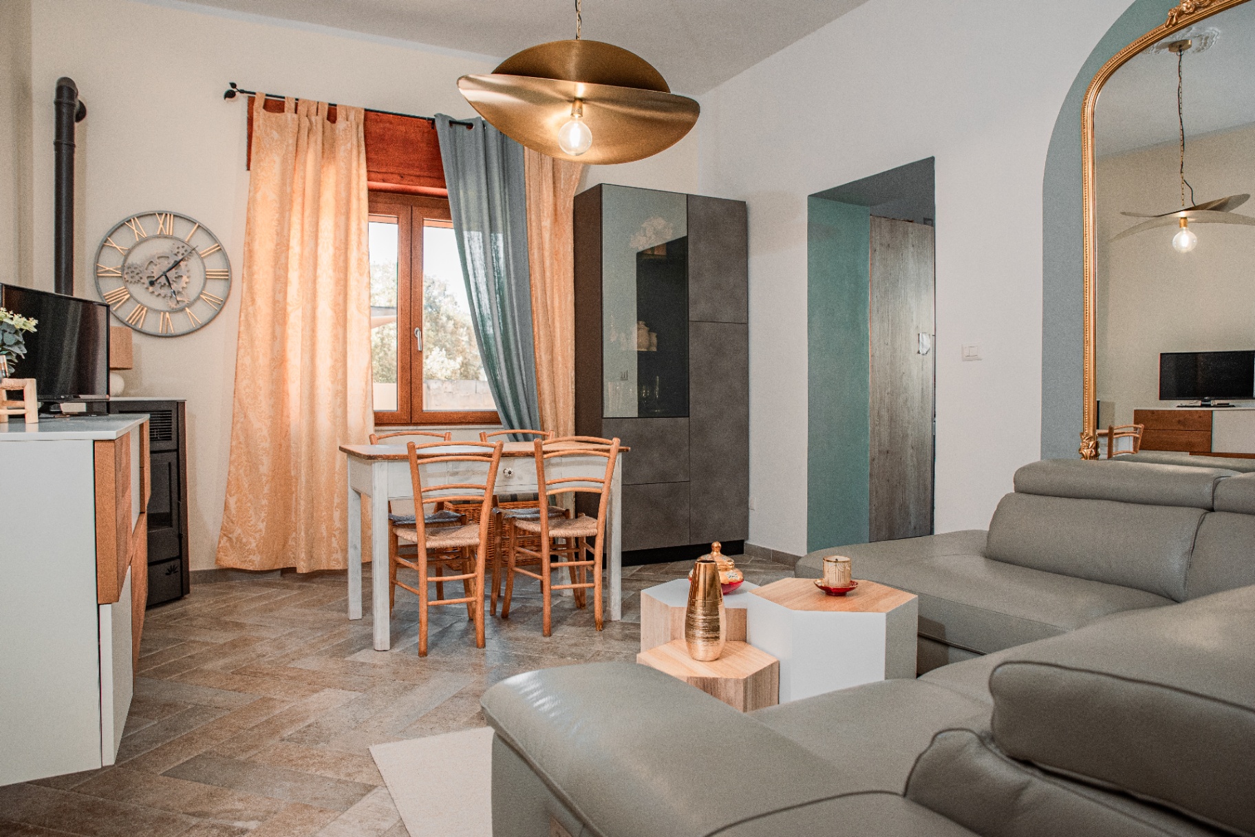 Séjour de Casa Antioca : poêle, table en bois et lumière du sud